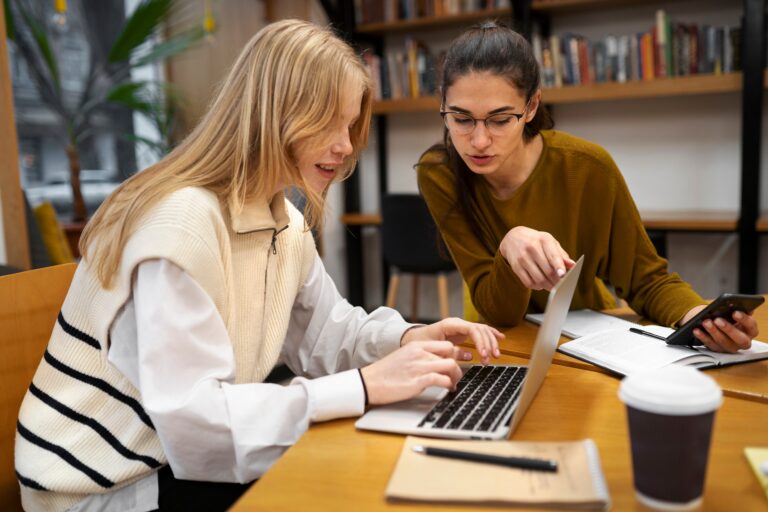 Two students working on a laptop