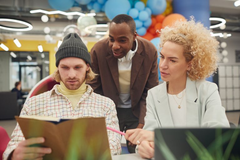 A diverse group of professionals working together in a modern office setting, fostering creativity and teamwork.