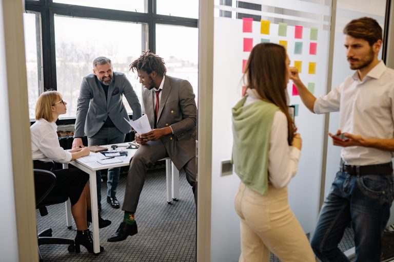 Office environment with diverse team members brainstorming and collaborating on a project.