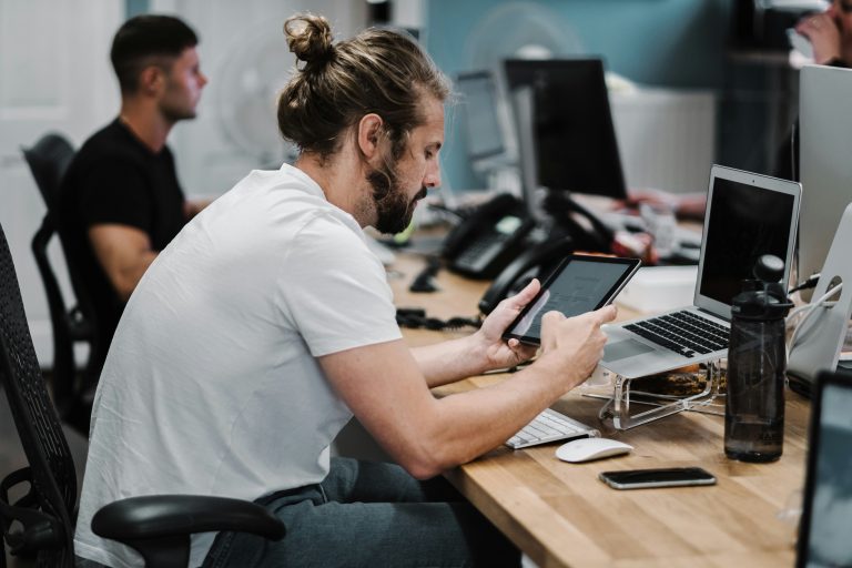 man-holding-turned-on-ipad-in-front-of-turned-off-macbook-air